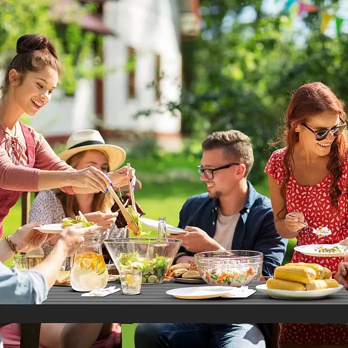Outsunny Gartentisch-Set - Gesamtumfang: 3 -tlg., Metall - Dunkelgrauer Lamellen-Outdoor-Tisch, der von Leuten für ein Picknick mit Essen und Getränken genutzt wird.