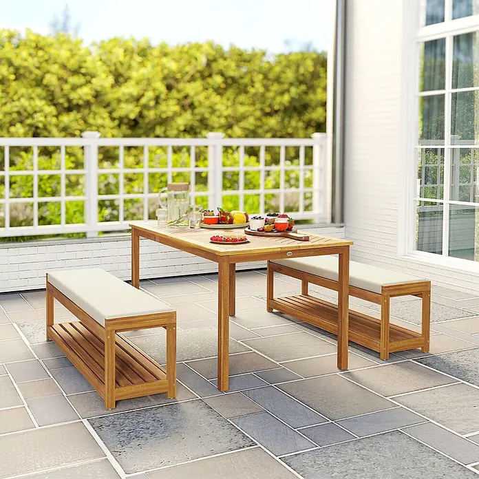 Outsunny Gartentisch-Set - Gesamtumfang: 3 -tlg., L x B x H: 150 x 85 x 75 cm, Akazienholz, Polyester, Schaumstoff - Eine Outdoor-Essgruppe aus Holz mit rechteckigem Tisch und zwei Bänken mit hellen Polstern.