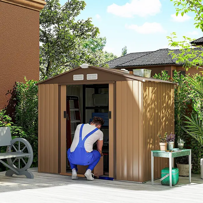 Outsunny Gerätehaus - Außenbreite inkl. Dachüberstand: 213 cm, Außentiefe inkl. Dachüberstand: 130 cm, Stahl, Gelb - Brauner Geräteschuppen auf einer Terrasse, eine Person lagert Gegenstände.
