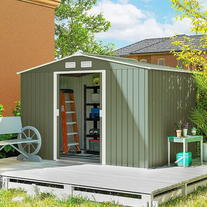 Outsunny Gerätehaus - Außenbreite inkl. Dachüberstand: 277 cm, Außentiefe inkl. Dachüberstand: 195 cm, Stahl, Hellgrün - Olivgrüner Metall-Gartenschuppen auf einer Holzterrasse, offen mit Regalen und Leiter, in einem sonnigen Hinterhof.