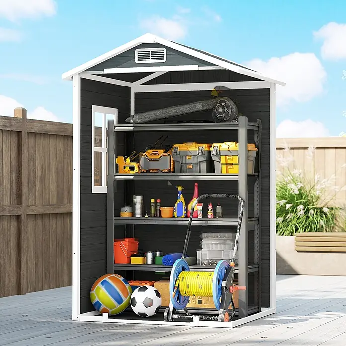 Outsunny Gerätehaus - Außenbreite inkl. Dachüberstand: 128 cm, Außentiefe inkl. Dachüberstand: 104 cm, Aluminium, Grau - Ein dunkelgrauer Outdoor-Geräteschuppen mit weißen Leisten und mehreren Regalen, gefüllt mit Werkzeugen und Gartengegenständen.