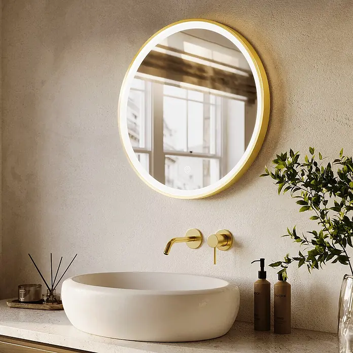 LOMAZOO Lichtspiegel LMZ-LONDON - Durchmesser: 60 cm, Gold - Ein runder, goldgerahmter, hintergrundbeleuchteter Spiegel über einem weißen Waschbecken in einem modernen Badezimmer.