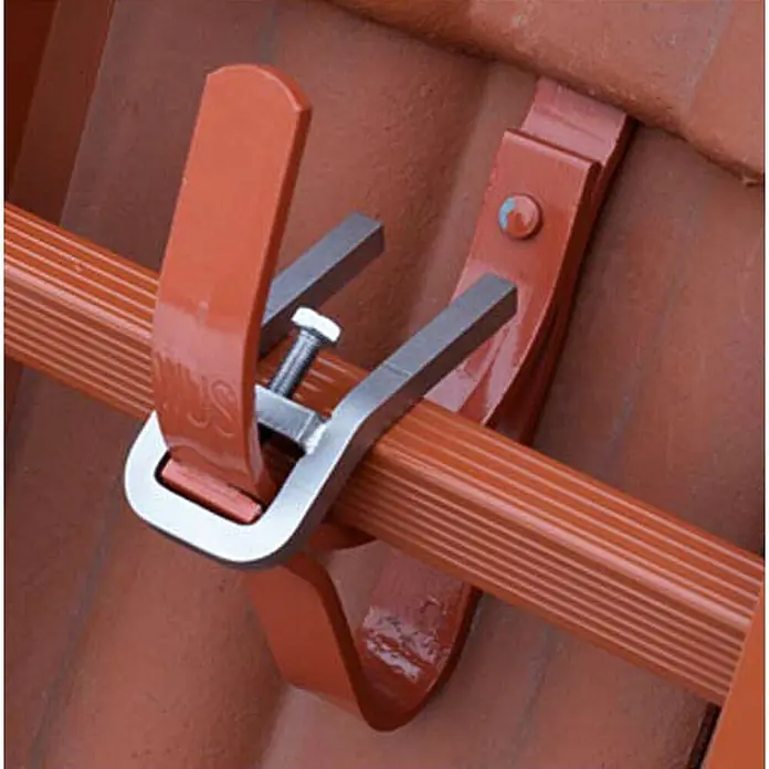 Zarges Dachleiter Dachleitersicherung für Dachhaken -  - Metall-Dachziegelklemme befestigt orangefarbenes Blitzschutzkabel an rotbraunem Dachziegel.