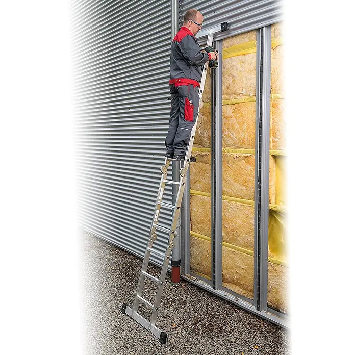 Euroline Mehrzweckleiter Premium 304 Klappleiter 4x3 Sprossen - Anzahl Tritte: 3 Stk., Arbeitshöhe: 4.400 m - Mehrzweckleiter aus silbernem Aluminium, von einem Arbeiter für Installationsarbeiten an einer Gebäudefassade genutzt.
