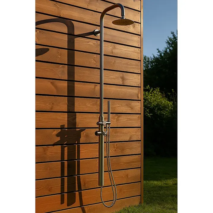 Ideal Eichenwald Pooldusche Modell 70 Gartendusche Juist wandmontiert - Edelstahl - Elegante Außendusche aus Edelstahl mit Regenbrause und flexibler Handbrause, an einer braunen Holzlattenwand montiert.
