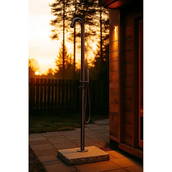 Ideal Eichenwald Pooldusche Modell 70 Gartendusche List für stark freuqentierte Bereiche - Edelstahl - Edelstahl-Außendusche neben einer Holzsauna, warm beleuchtet im Sonnenuntergang. Mit Handbrause.