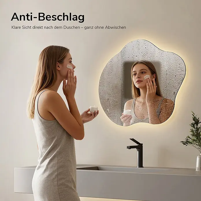 Emke Lichtspiegel Dimlite LM31 -  - Unregelmäßig geformter, beleuchteter Anti-Beschlag Badspiegel mit klarer Reflexion einer Frau in dampfiger Umgebung.