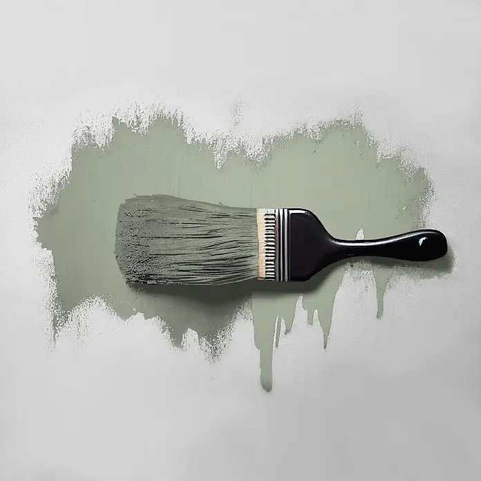 Tadessi Wandfarbe Sage Green - Grün, Matt, 5 l - Ein Pinsel mit schwarzem Griff streicht hellgrüne Farbe auf eine Wand und hinterlässt Pinselstriche und Farbtropfen.