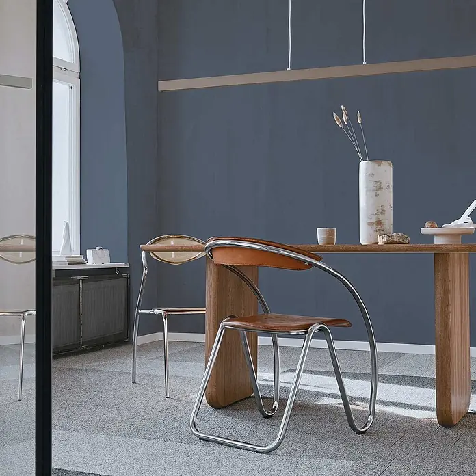 Tadessi Wandfarbe Taubenblau - Blau, Matt, 2,5 l - Moderne Esszimmerstühle mit Chromgestellen und braunen Ledersitzen, kombiniert mit einem Massivholz-Esstisch in einem modernen Raum.