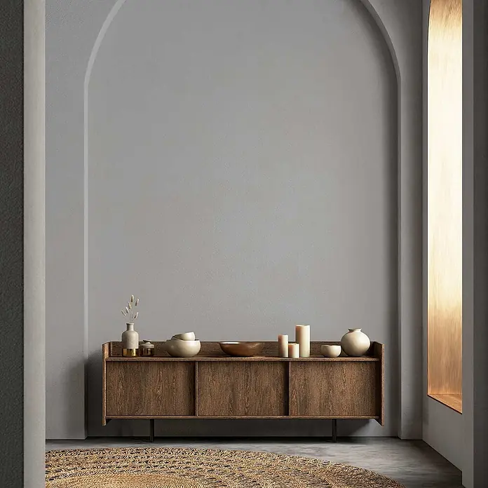 Tadessi Wandfarbe Stahlgrau - Grau, Matt, 2,5 l - Dunkelbraunes Holzsideboard mit Schiebetüren, dekoriert mit Keramik und Kerzen in einem modernen Raum.