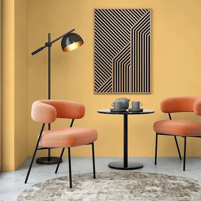 Tadessi Wandfarbe Strohgelb - Gelb, Matt, 5 l - Eine gemütliche Sitzecke mit zwei orangefarbenen Stoffstühlen, einem schwarzen Beistelltisch und einer schwarzen Stehlampe.
