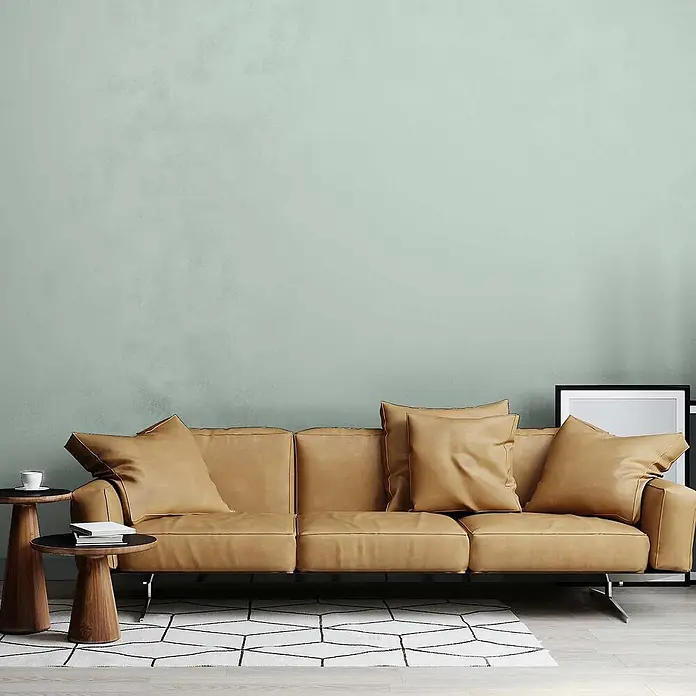 Tadessi Wandfarbe Eukalyptus - Grün, Matt, 5 l - Ein hellbraunes Ledersofa mit Kissen, das bequeme Sitzgelegenheiten in einem modernen Wohnzimmer bietet.