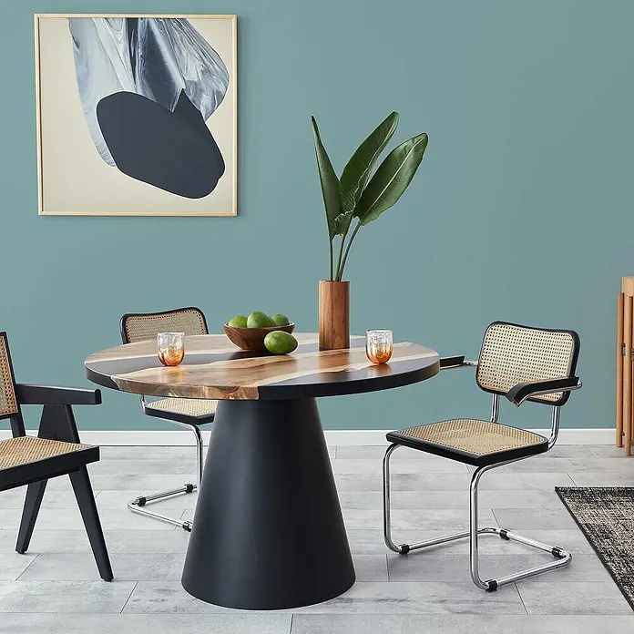 Tadessi Wandfarbe Laugenblau - Blau, Matt, 1 l - Modernes Esszimmer-Set: Holztisch mit schwarzem Fuß und Stühle mit Rohrgeflecht.