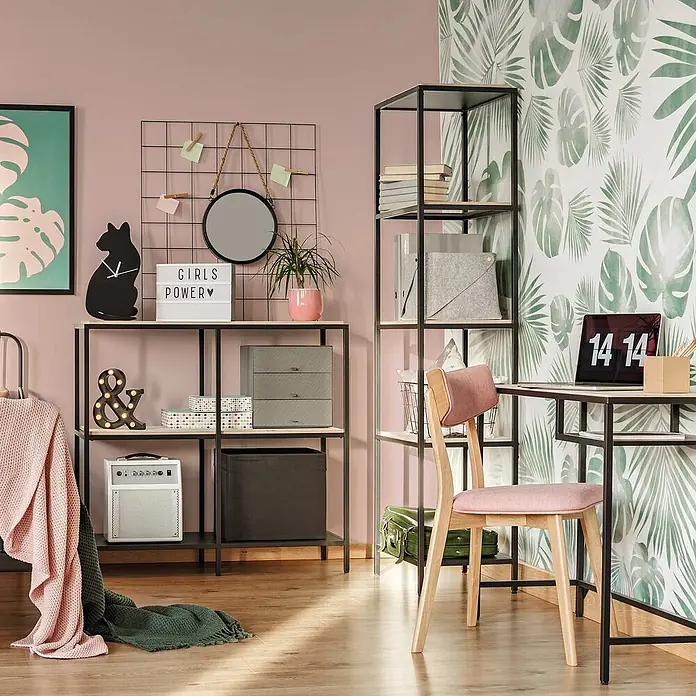 Tadessi Wandfarbe Tauperosa - Rosa, Matt, 5 l - Schwarzer Metallschreibtisch mit heller Holzplatte und integriertem Regal, dazu ein rosa Polsterstuhl, in moderner Raumgestaltung.