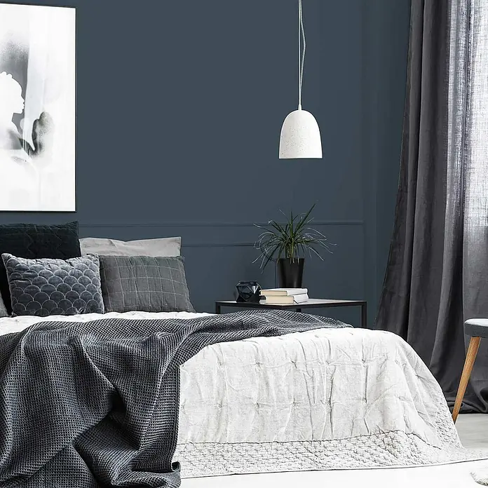 Tadessi Wandfarbe Taupe - Blau, Matt, 2,5 l - Modernes Schlafzimmer mit einem Bett, ausgestattet mit weißer Steppdecke, dunkelgrauem Waffelplaid und grauen Kissen.