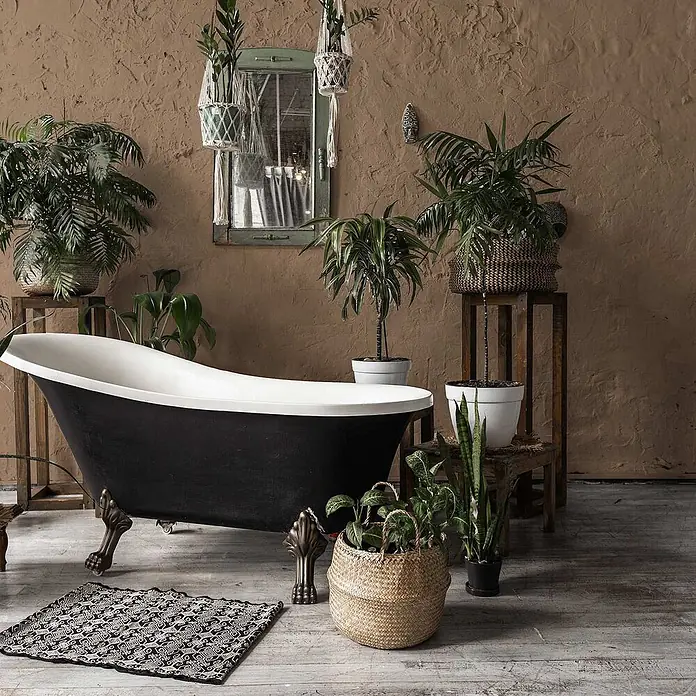 Tadessi Wandfarbe Lederbraun - Braun, Matt, 2,5 l - Eine schwarz-weiße Klauenfuß-Badewanne in einem üppigen, pflanzenreichen Boho-Badezimmer.