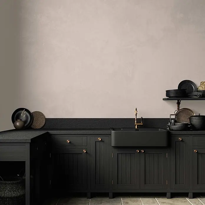 Tadessi Wandfarbe Vanillecreme - Beige, Matt, 1 l - Schwarze Küchenschränke, Spüle und Messinghahn in einer modernen Küche mit beigefarbener Wand.
