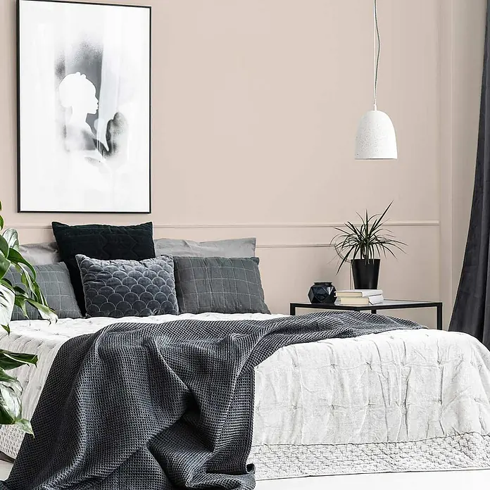 Tadessi Wandfarbe Vanillecreme - Beige, Matt, 1 l - Dunkelgraue Waffelstrickdecke auf einem Bett mit verschiedenen grauen Kissen in einem modernen Schlafzimmer.