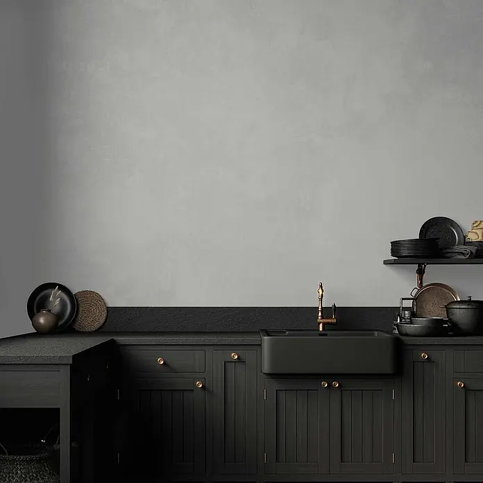 Tadessi Wandfarbe Kieselgrau - Grau, Matt, 1 l - Dunkle Holz-Küchenschränke, schwarze Arbeitsplatte und Spüle mit Messing-Wasserhahn.