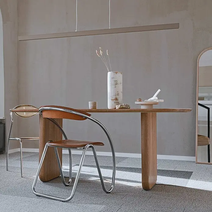 Tadessi Wandfarbe Kieselgrau - Grau, Matt, 1 l - Moderner Essbereich mit hellem Holztisch, eleganten Chrom- und Lederstühlen und einer linearen Pendelleuchte.