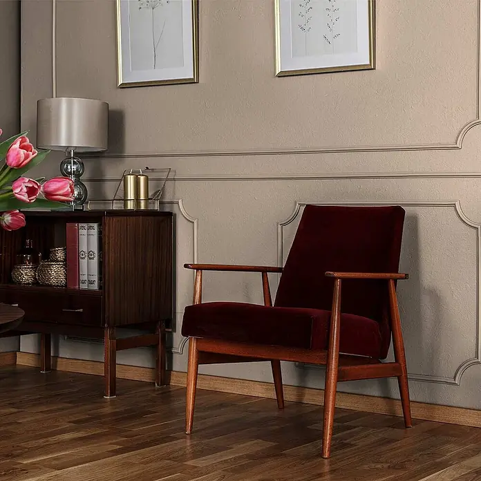 Tadessi Wandfarbe Antikweiß - Beige, Matt, 5 l - Eleganter Mid-Century Sessel mit rotem Samtbezug und dunklem Holzrahmen im Wohnzimmer.