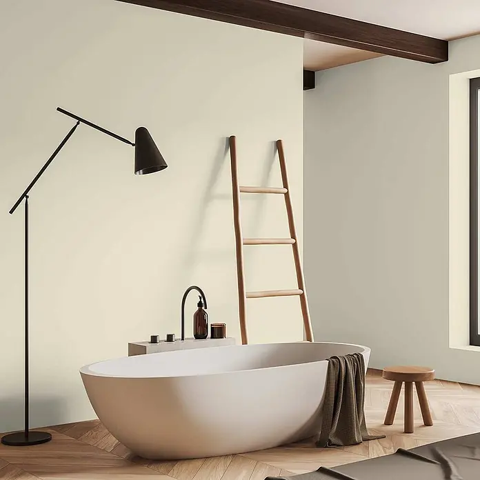 Tadessi Wandfarbe Koralle - Grün, Matt, 5 l - Eine weiße freistehende Badewanne in einem modernen Badezimmer mit Holzfußboden, neben einer schwarzen Stehlampe.