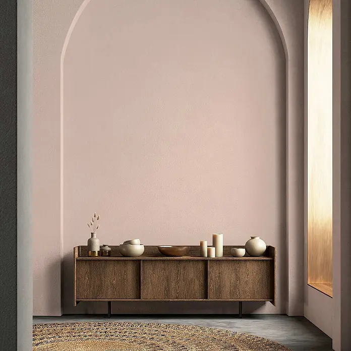Tadessi Wandfarbe Lehm - Rosa, Matt, 1 l - Ein stilvolles Sideboard aus dunklem Holz mit Schiebetüren, dekoriert mit Keramikschalen und Kerzen, in einem modernen Raum.