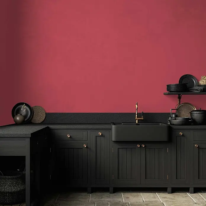 Tadessi Wandfarbe Rose - Pink, Matt, 2,5 l - Schwarze Küchenschränke, Spüle und Arbeitsplatte kombiniert mit einer roten Wand.