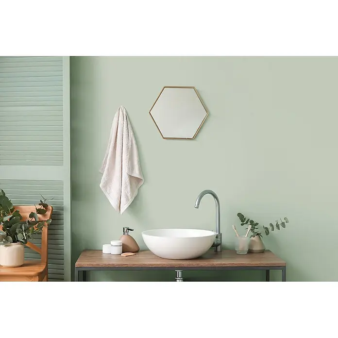 Tadessi Wandfarbe Sage Green - Grün, Matt, 5 l - Weißes Aufsatzwaschbecken mit silbernem Schwanenhals-Wasserhahn auf einem Holzwaschtisch in einem modernen Badezimmer.