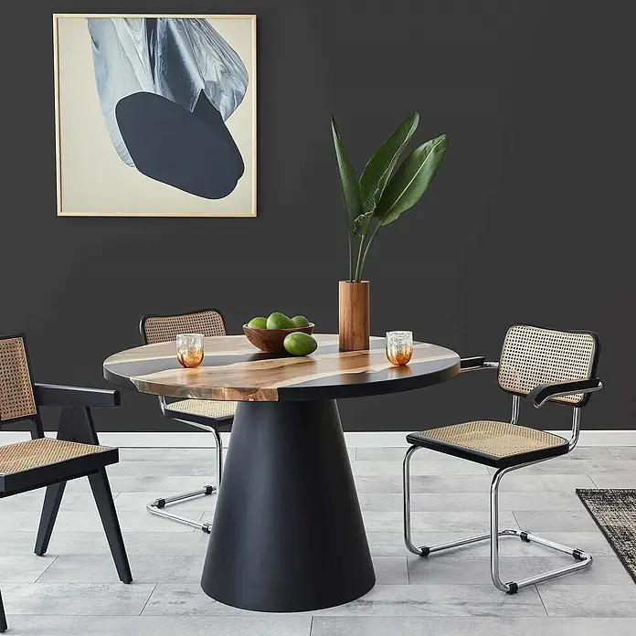 Tadessi Wandfarbe Anthrazitgrau - Schwarz, Matt, 1 l - Modernes Esszimmer-Set mit rundem, gestreiftem Holztisch auf schwarzem Fuß, kombiniert mit schwarzen Rohrgeflecht-Stühlen.