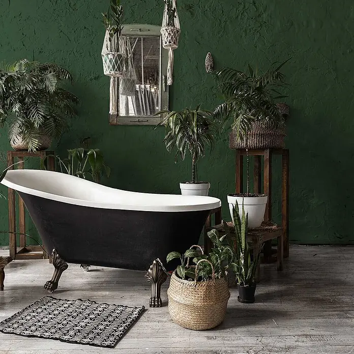 Tadessi Wandfarbe Tannengrün - Grün, Matt, 5 l - Eine klassische schwarz-weiße Badewanne mit Klauenfüßen aus Bronze in einem pflanzenreichen Badezimmer.