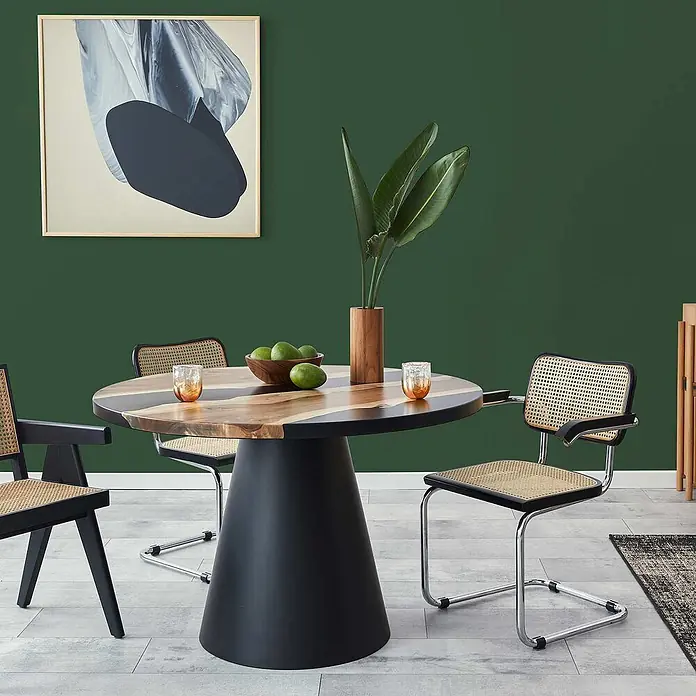 Tadessi Wandfarbe Tannengrün - Grün, Matt, 5 l - Ein modernes Esszimmer-Set mit einem runden Holztisch mit schwarzem Fuß und Stühlen mit Wiener Geflecht im Essbereich.