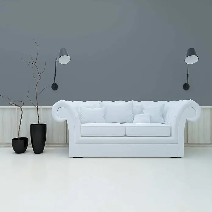 Tadessi Wandfarbe Blaugrau - Grau, Matt, 1 l - Weißes getuftetes Sofa mit mehreren Kissen in einem modernen Wohnraum.