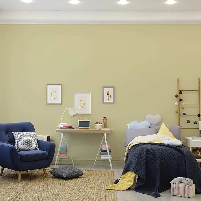 Tadessi Wandfarbe Blassgrün - Grün, Matt, 1 l - Gemütliches Zimmer mit blauem Sessel, Schreibtisch und Bett mit dunkelblauer Decke, ideal für verschiedene Aktivitäten.