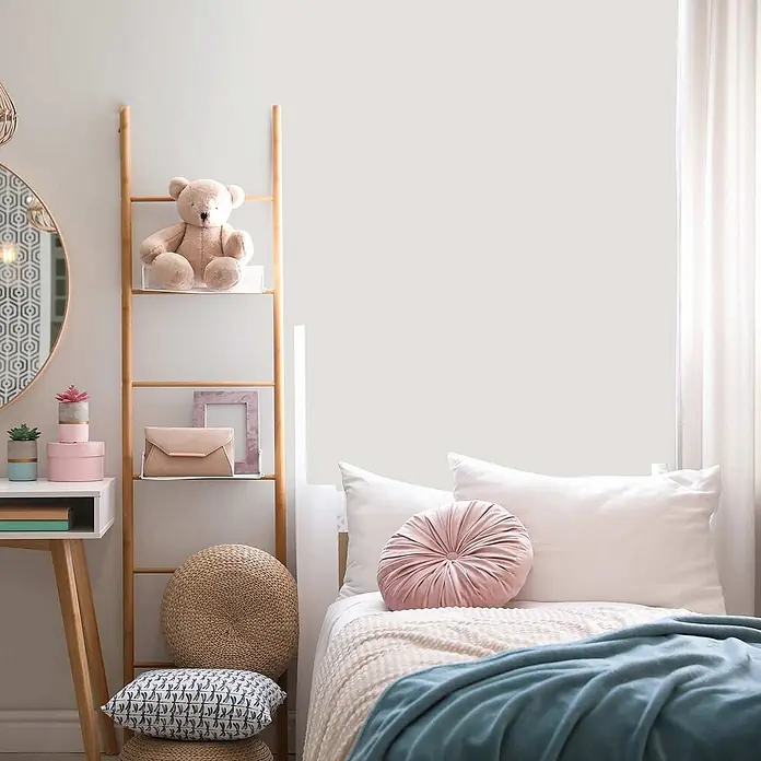 Tadessi Wandfarbe Perlmutt - Creme, Matt, 5 l - Ein plüschiger beiger Teddybär auf einem Regal in einem gemütlichen Schlafzimmer.