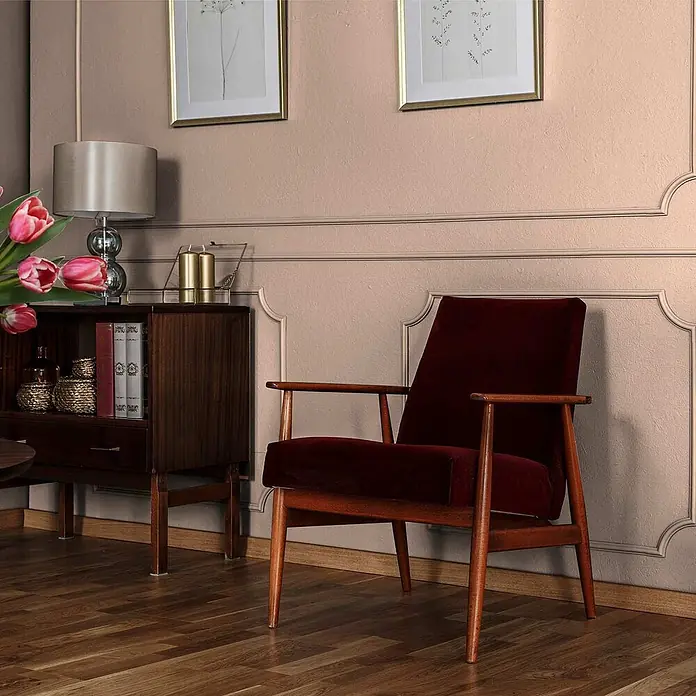 Tadessi Wandfarbe Blütenrosa - Rosa, Matt, 2,5 l - Dunkelroter Samtsessel mit rotbraunem Holzrahmen, in einem gemütlichen Wohnzimmer platziert.