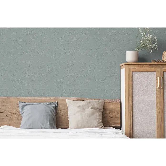 Tadessi Wandfarbe Sage Green - Grün, Matt, 5 l - Salbeigrüntapete mit Textur an einer Schlafzimmerwand hinter einem Bett angebracht.