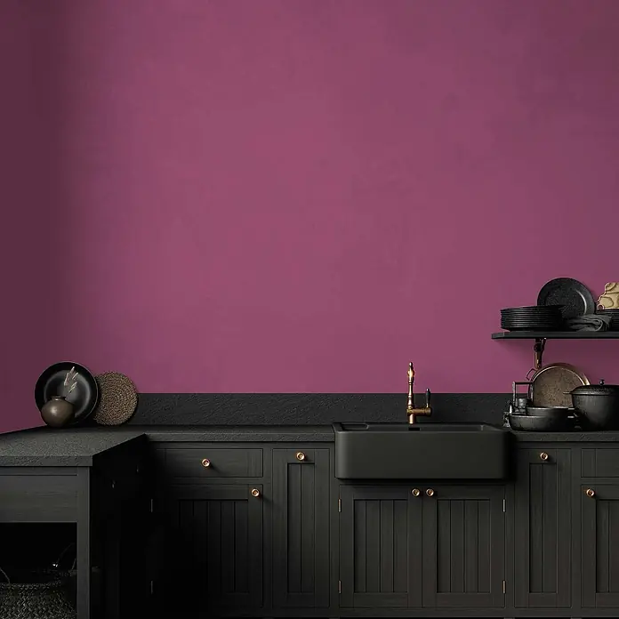 Tadessi Wandfarbe Weinrot - Pink, Matt, 5 l - Kräftige magentafarbene Wand in einer stilvollen Küche mit schwarzen Schränken.