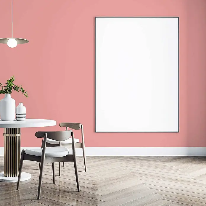 Tadessi Wandfarbe Erdbeerrosa - Pink, Matt, 1 l - Großer weißer rechteckiger Rahmen mit schwarzem Rand, an einer rosafarbenen Wand montiert, als modernes Designelement in einem Esszimmer.
