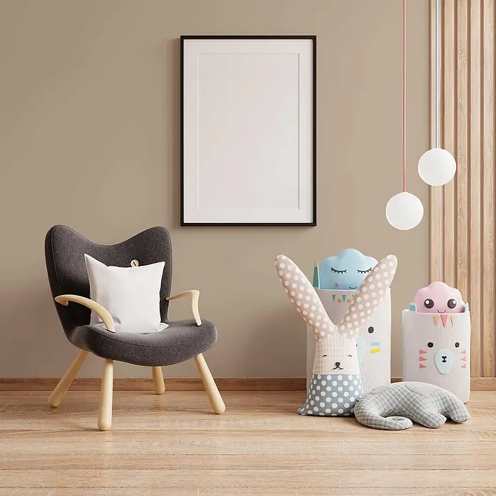 Tadessi Wandfarbe Sandweiß - Beige, Matt, 5 l - Schwarzer Bilderrahmen mit weißem Passepartout an beiger Wand über grauem Sessel im Kinderzimmer.