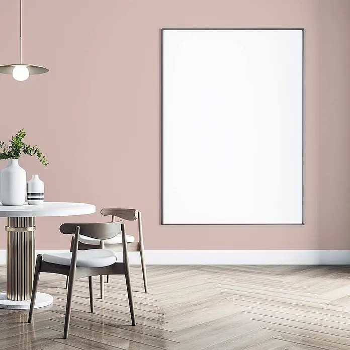 Tadessi Wandfarbe Lachston - Rosa, Matt, 5 l - Großer weißer Hochformatrahmen mit schmalem dunklem Rand, an einer rosa Wand in einem modernen Esszimmer.