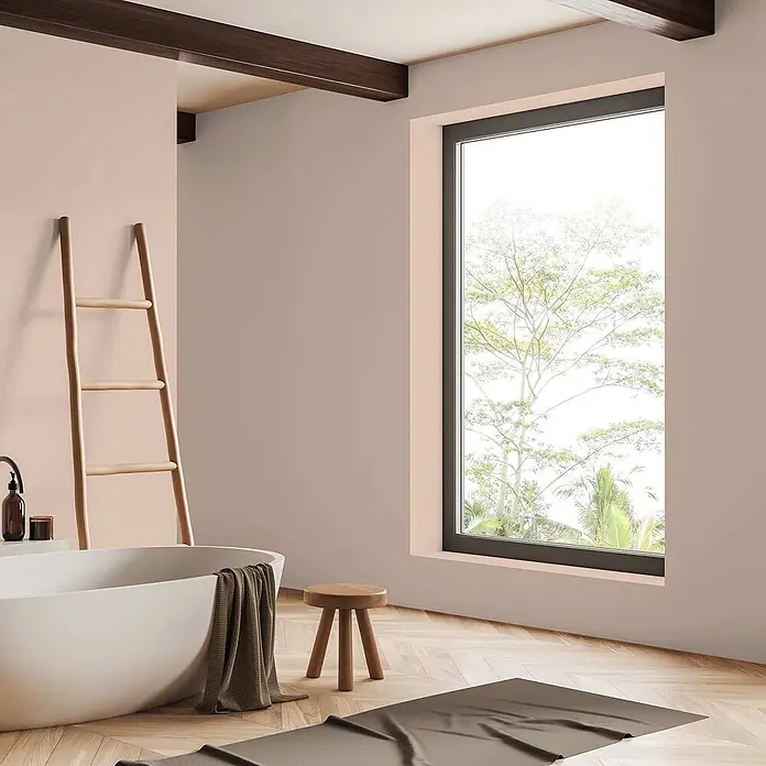 Tadessi Wandfarbe Blasskoralle - Beige, Matt, 2,5 l - Modernes Bad mit weißer Badewanne, Holzleiter und Hocker. Dunkle Handtücher liegen auf der Wanne und dem hellen Holzfußboden.