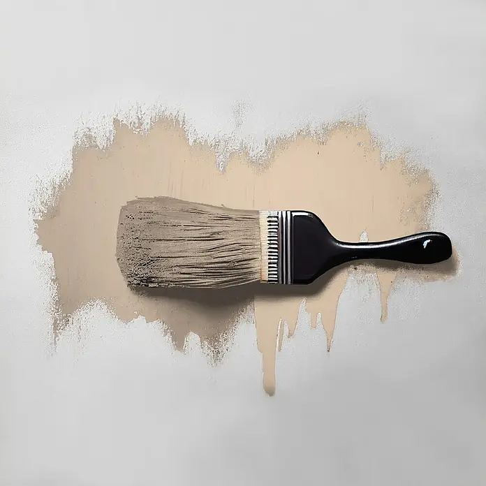 Tadessi Wandfarbe Honig Mocha - Beige, Matt, 5 l - Pinsel mit schwarzem Griff, Borsten mit beigefarbener Farbe bedeckt, auf einer strukturierten Wand.
