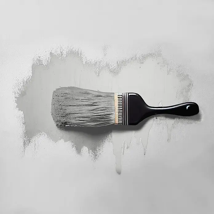 Tadessi Wandfarbe Perlgrau - Grau, Matt, 2,5 l - Ein Pinsel mit schwarzem Griff und grauen Borsten, der graue Farbe auf eine helle Oberfläche aufträgt.