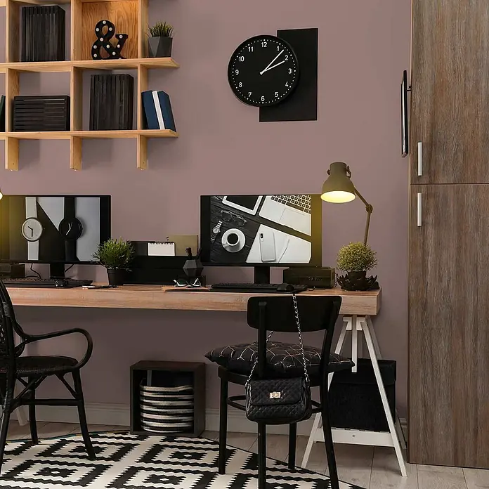 Tadessi Wandfarbe Mandel - Braun, Matt, 1 l - Ein modernes Heimbüro mit langem Holzschreibtisch, zwei schwarzen Stühlen und zwei Monitoren vor einer mauvefarbenen Wand.