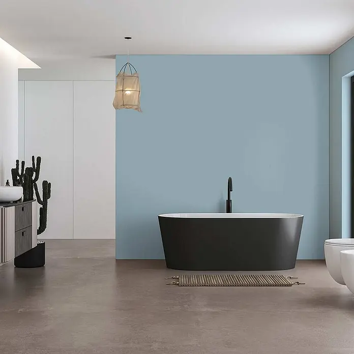 Tadessi Wandfarbe Wasserblau - Blau, Matt, 2,5 l - Schwarze freistehende Badewanne in einem modernen Bad mit hellblauer Wand und minimalistischer schwarzer Armatur.