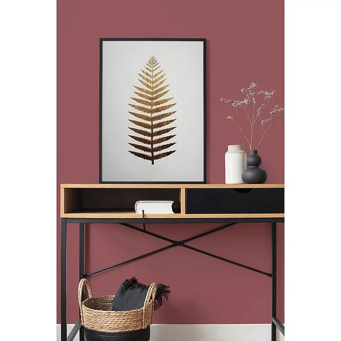 Tadessi Wandfarbe Bordeaux Cherry Rot - Rot, Matt, 2,5 l - Konsolentisch aus hellem Holz mit schwarzem Metallrahmen, dekoriert mit Farnprint und Dekoartikeln.