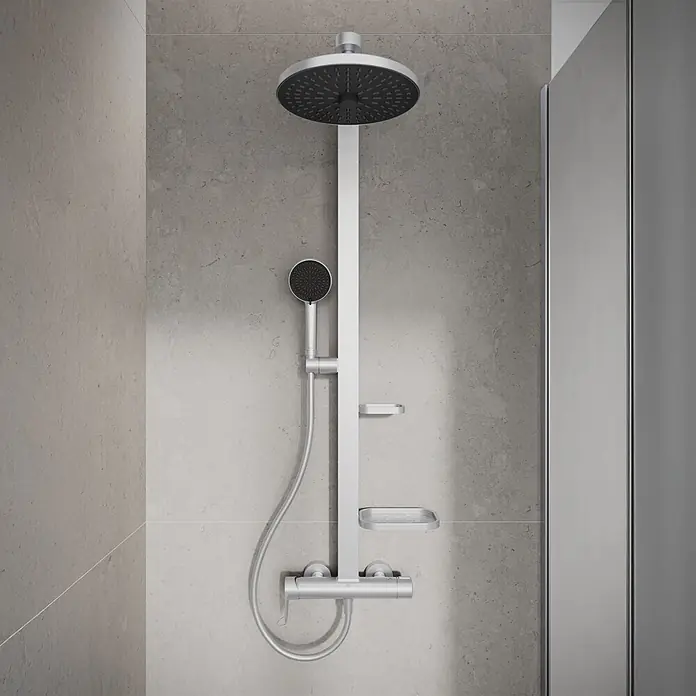 Ideal Standard Alu+ Duschsystem Ceraflow BD584SI - Lochabstand: 60 cm, Anzahl Strahlarten: 2 Stk., Silber, Form Kopfbrause: Rund - Silbernes Duschsystem mit großer Kopfbrause und Handbrause, inklusive Thermostatmischer und zwei Seifenschalen, an einer grauen Fliesenwand montiert.