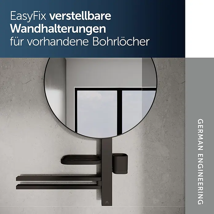Ideal Standard Alu+ Ablagespiegel - B x H: 640 x 817 mm, Schwarz - Dunkelgraue verstellbare Wandhalterung mit Ablagen und Becher, unter einem runden Spiegel an einer Betonwand.