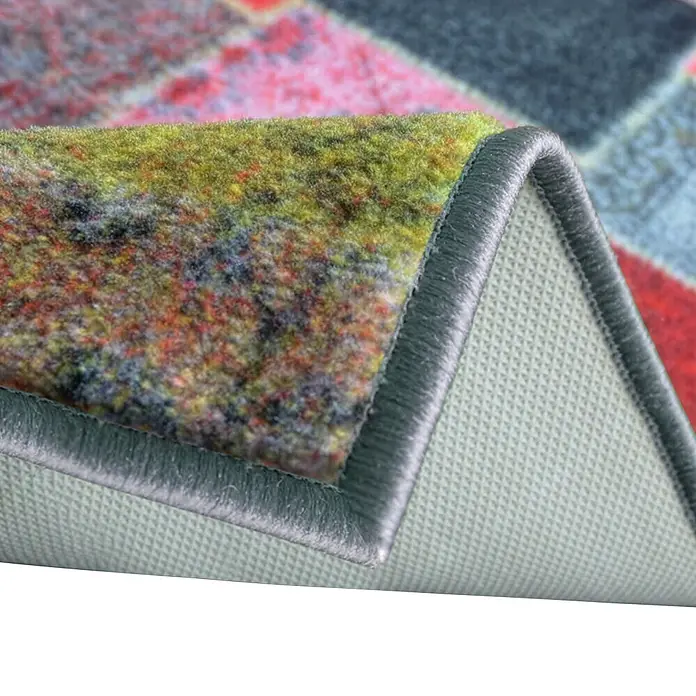 Teppichläufer Monsano - Bunt, 250 x 80 cm, 100 % Polyamid - Nahaufnahme eines mehrfarbig gemusterten Teppichs mit angehobener Ecke, die die strukturierte Oberfläche, die graue Einfassung und die hellgraue Antirutschunterseite zeigt.